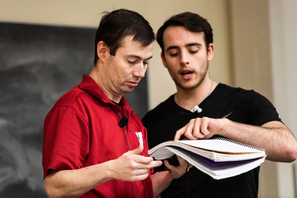 Matt Bowman and student look over a textbook together