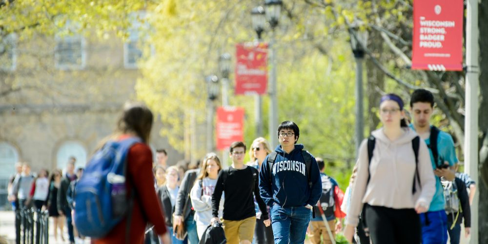 Students walk down the sidewalk of Bascom Hill during spring at the University of Wisconsin-Madison