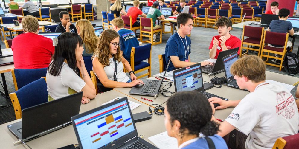 students registering for classes at laptop computers in a library