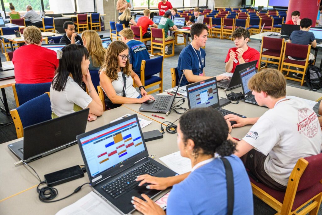 students registering for classes at laptop computers in a library