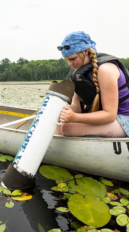 Two UW–Madison students in a canoe collect data from Allequash Lake