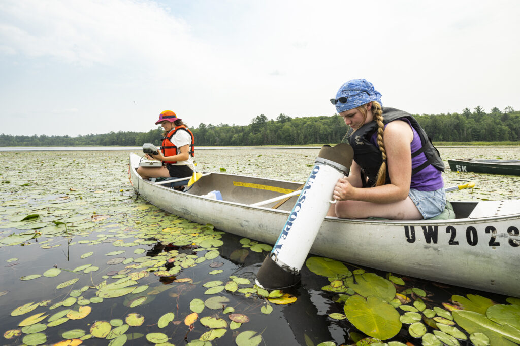 Two UW–Madison students in a canoe collect data from Allequash Lake