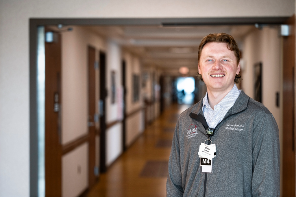 Shane Hoffman smiling in the hallway of a medical facility