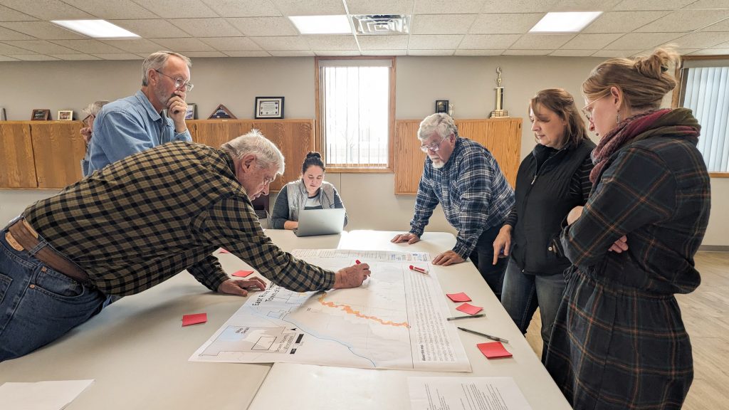 People gather around a map.